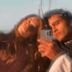 a man and a woman are taking a selfie together .