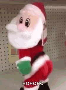 a stuffed santa claus is standing on a shelf in a store and holding a cup .