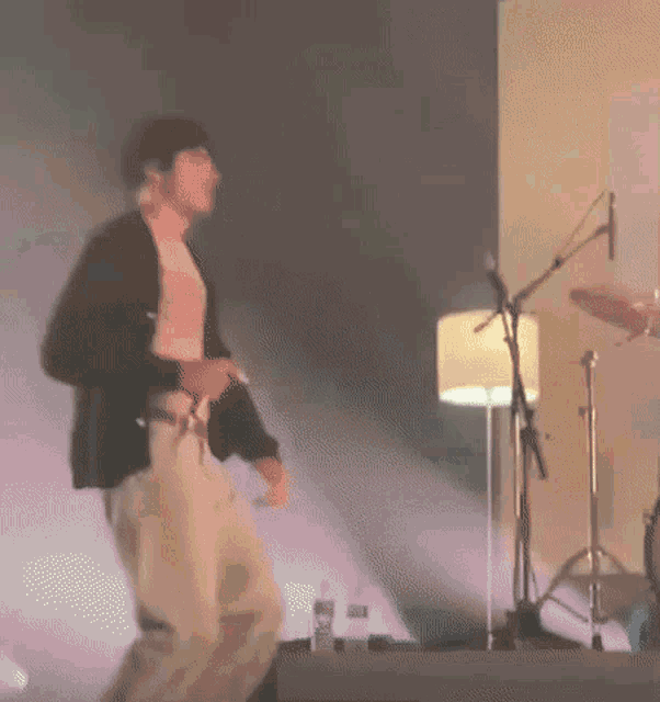 a man is standing on a stage in front of a microphone