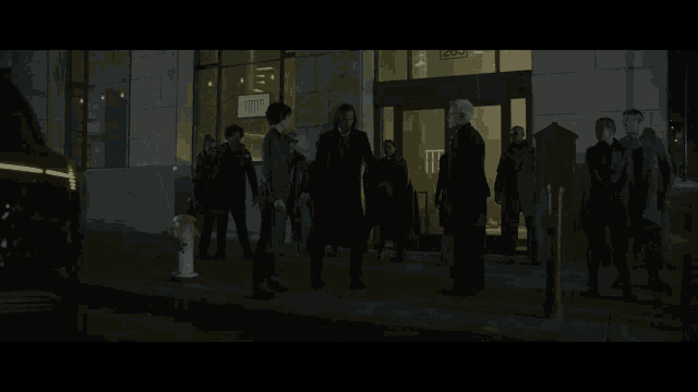 a group of people are standing in front of a building that has a sign that says t.t.