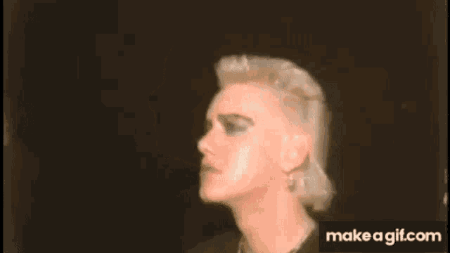 a close up of a man 's head with a mohawk and earrings .