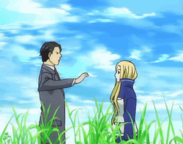 a man and a woman are standing in the grass talking