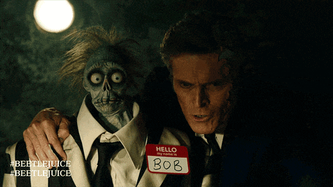a man holding a puppet with a name tag that says bob on it