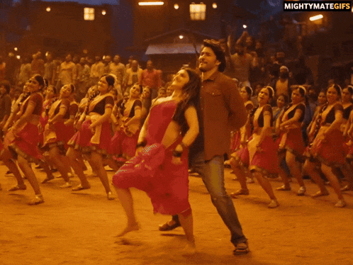 a man and a woman are dancing in front of a crowd with the words mightymategifs on the bottom