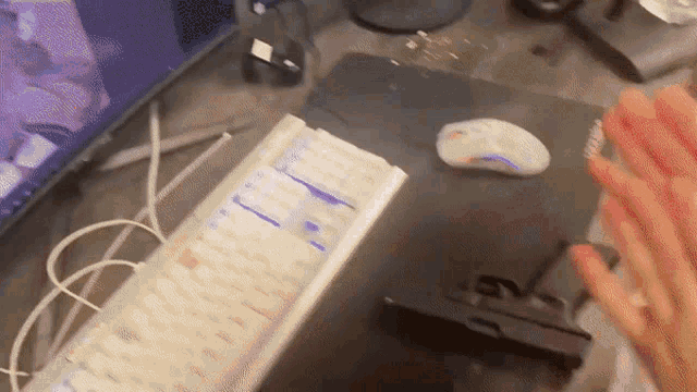 a person is clapping in front of a keyboard and a mouse