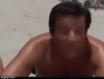 a man is laying on his stomach on the beach .