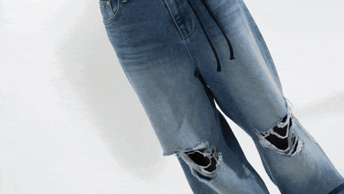 a person wearing a pair of ripped blue jeans
