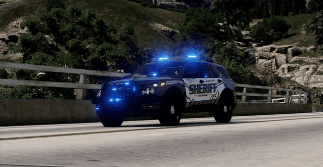 a sheriff 's car is driving down a highway