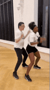a man and a woman are dancing together on a wooden floor