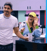 a man and a woman are standing in a kitchen .