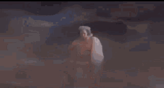 a shirtless man with long white hair is standing in the dark .