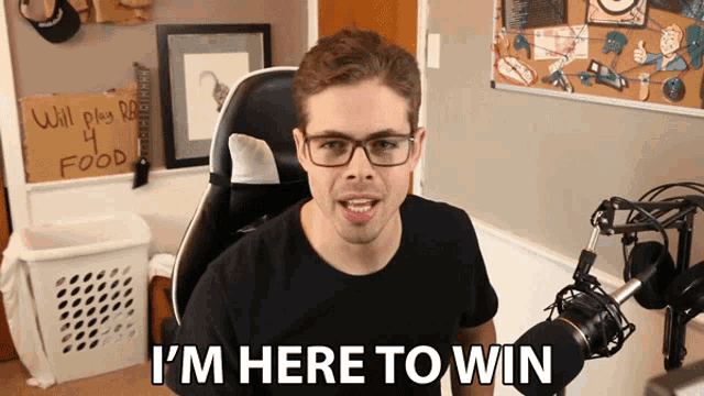 a man wearing glasses says i 'm here to win
