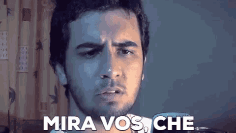 a man with a beard is making a funny face and says mira vos che