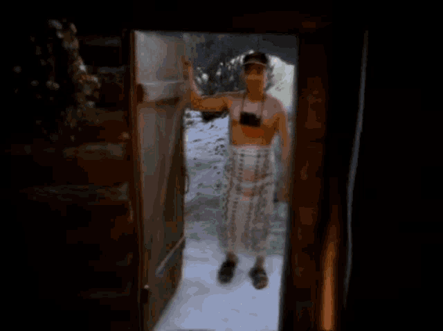 a man without a shirt is standing in an open doorway