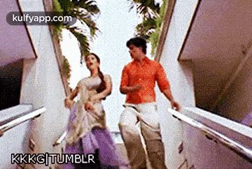 a man and a woman are dancing on stairs .