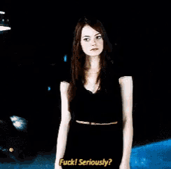a woman in a black dress is standing in front of a black background and says " fuck seriously "