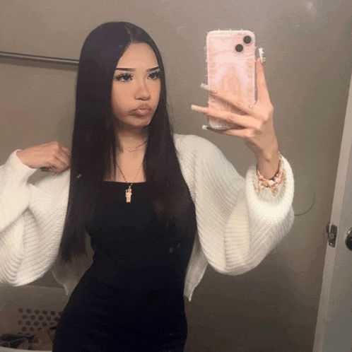 a woman taking a picture of herself in the mirror with her phone