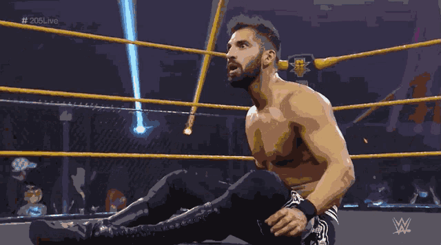 a shirtless wrestler in a wrestling ring with the hashtag # 205live on the bottom