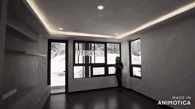 a woman is standing in an empty bedroom with the words bedroom 2 written on the wall