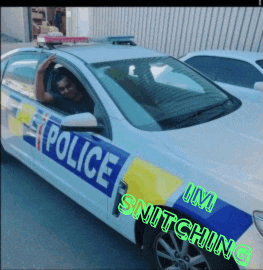 a man is sitting in a police car that says police snitching on the side