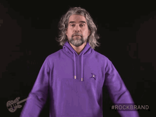 a man is wearing a purple hoodie with the #rockbrand hashtag