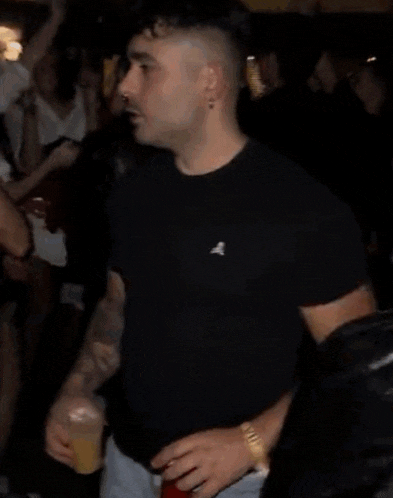 a man in a black nike shirt is holding a red can of soda