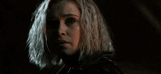 a close up of a woman 's face in the dark with a tear running down her cheek .