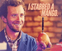 a man is holding a mango with a needle sticking out of it and the words i stabbed a mango behind him