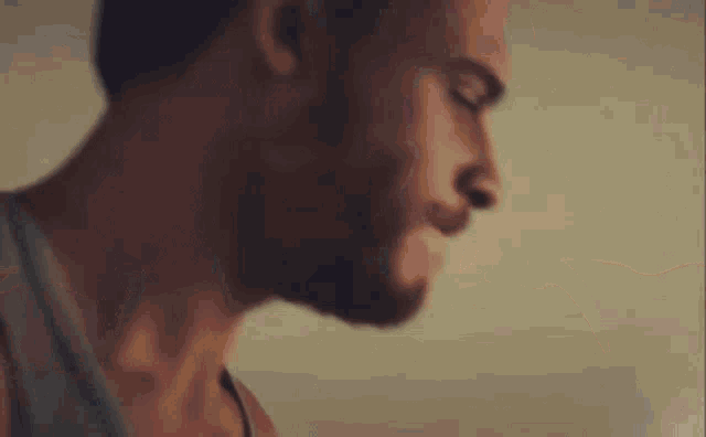 a close up of a man 's head and neck against a wall .