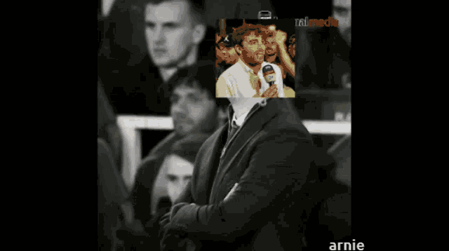 a man in a suit has a picture of a man behind him with the word annie on the bottom