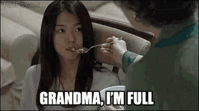 a woman is feeding another woman with a spoon and says `` grandma , i 'm full ''