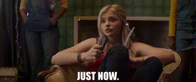 a woman is sitting on a couch with her legs crossed and the words `` just now '' written on the screen .