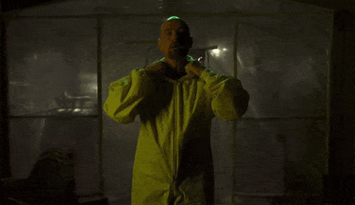 a man in a yellow protective suit is standing in front of a clear plastic wall