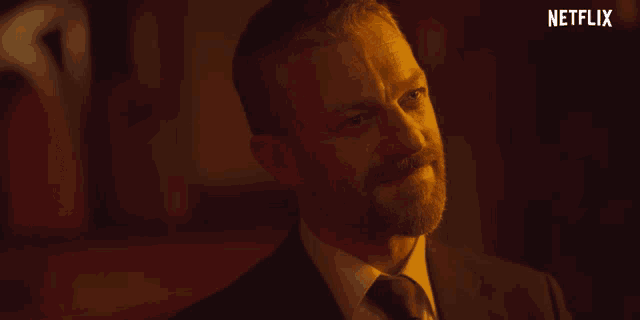 a man in a suit and tie with a netflix logo on the bottom