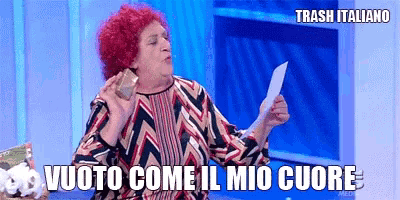 a woman with red hair is holding a piece of paper in her hand and says vuoto come il mio cuore