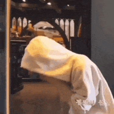 a person is standing in front of a door with their head in the doorway .