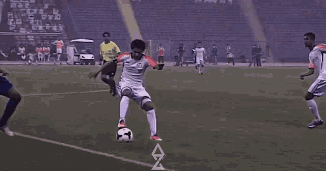 a soccer game is being played on a field with a referee wearing a yellow shirt that says ' e '