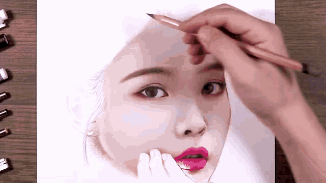 a person is drawing a girl 's face with a pencil