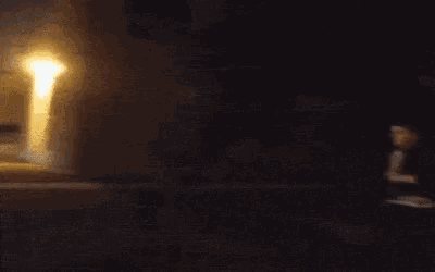 a person is doing a trick on a skateboard in front of a building at night