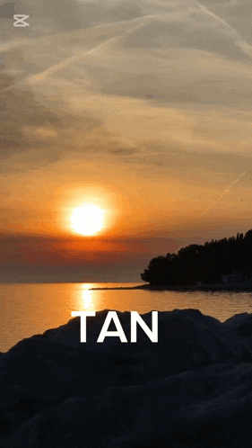 a sunset over a body of water with the word tan