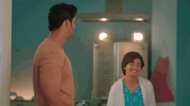 a man and woman are dancing together in a kitchen