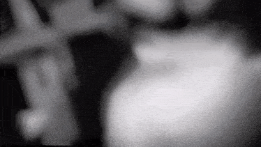 a black and white photo of a person 's face with a blurred background .