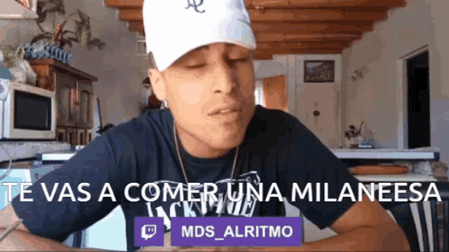 a man wearing a white hat and a black shirt with the words te vas a comer una milanesa