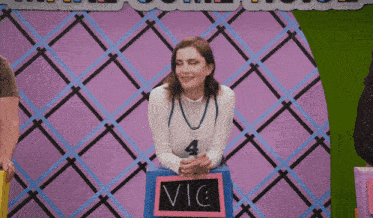 a woman with the number 4 on her shirt is holding a sign with the name vic on it