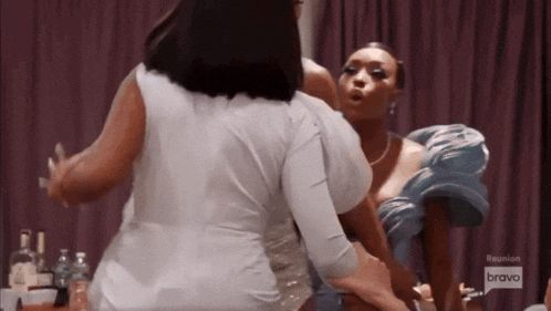 a group of women are standing next to each other in a room having a fight .