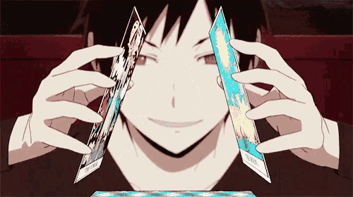 a person is holding two cards in front of their face and smiling .