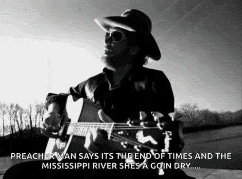 a man in a cowboy hat playing a guitar