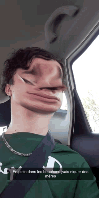 a man in a green shirt is sitting in a car with a caption that says en plein dans les bouchons