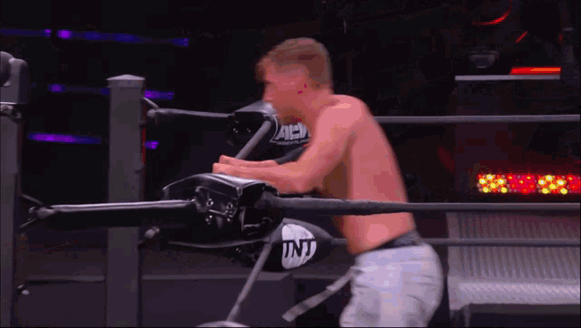a man in a boxing ring with a tnt glove on
