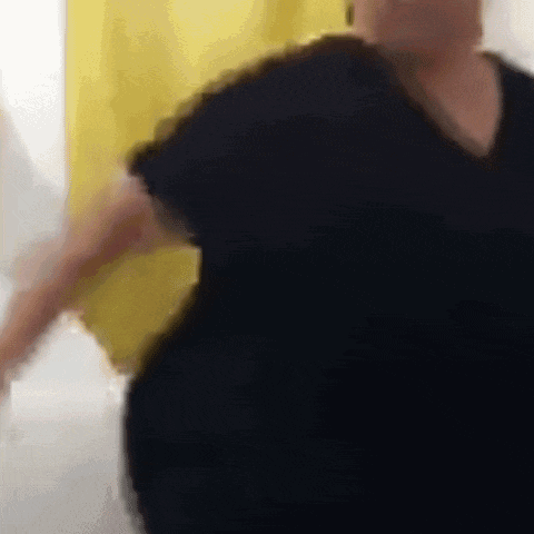 a man in a black shirt is dancing in front of a yellow curtain .